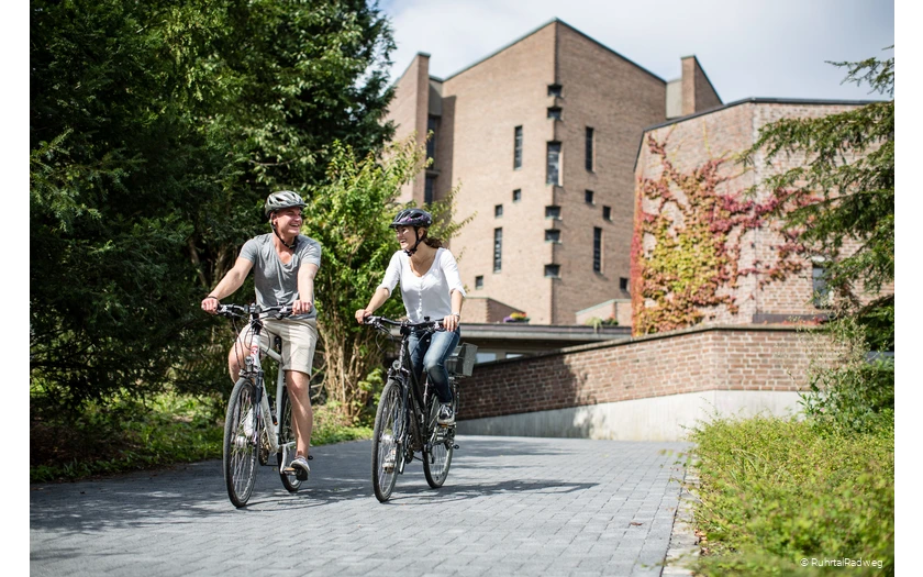 Radfahrer vor der Abtei Königsmünster in Meschede