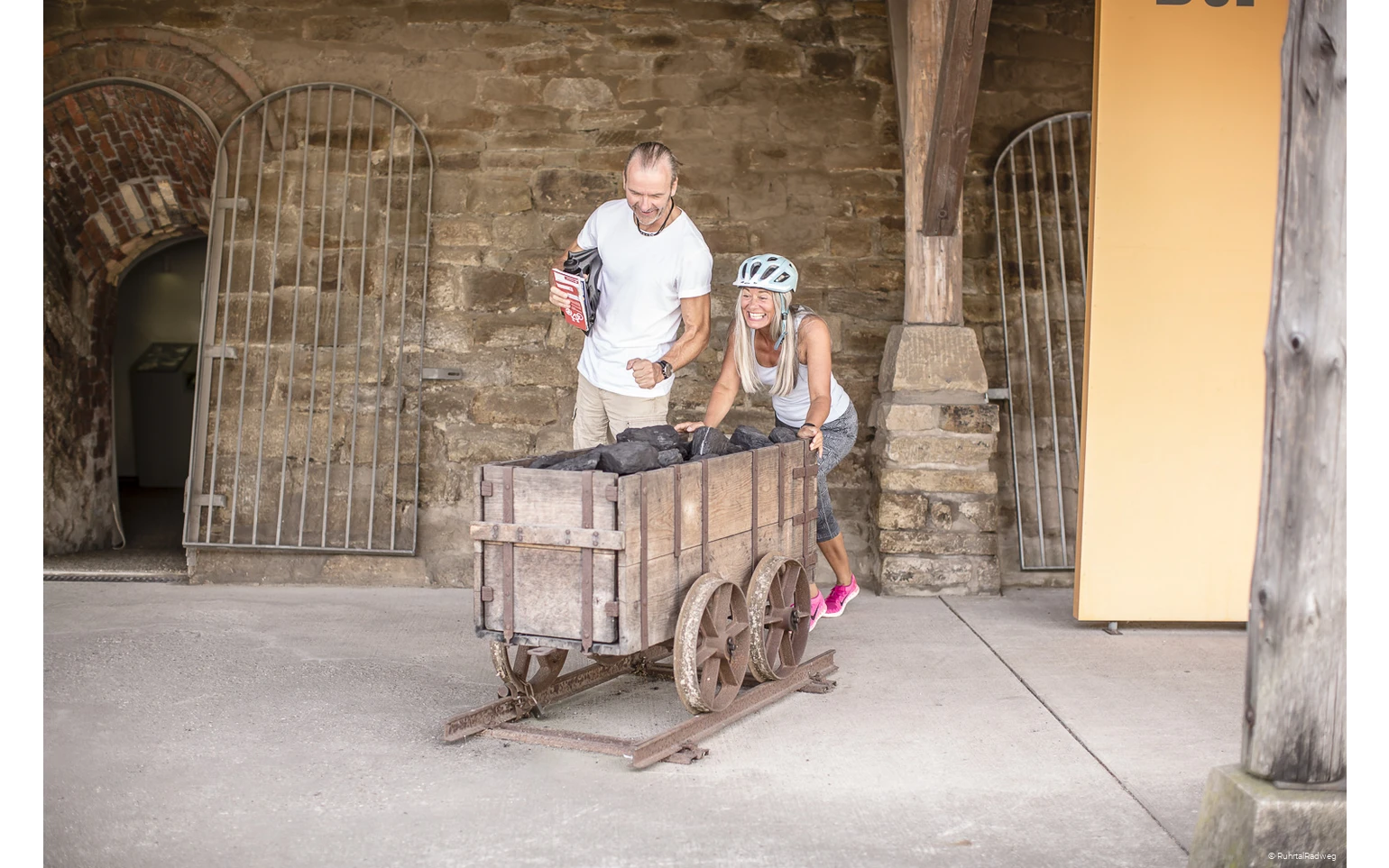 Paar schiebt einen Bergbauwaagen an der Zeche Nachtigall