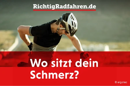 Radfahrer mit Rückenschmerzen fasst sich an den Rücken