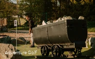 Eine Golfbahn mit einem Bergbau-Waggon als Hindernis.