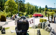Eine Golfbahn mit einem Bergwerk-Waggon als Hindernis.