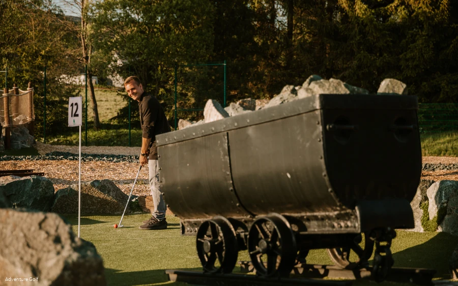 Eine Golfbahn mit einem Bergbau-Waggon als Hindernis.