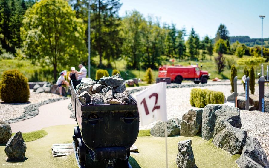 Eine Golfbahn mit einem Bergwerk-Waggon als Hindernis.