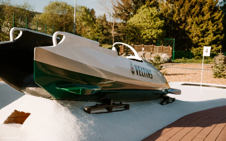 Ein Hindernis in Form eines Bobs auf einer Golfbahn.