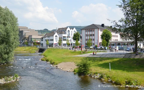 Zwei Menschen auf einer Treppe am Ufer der Ruhr. Gebäude im Hintergrund.