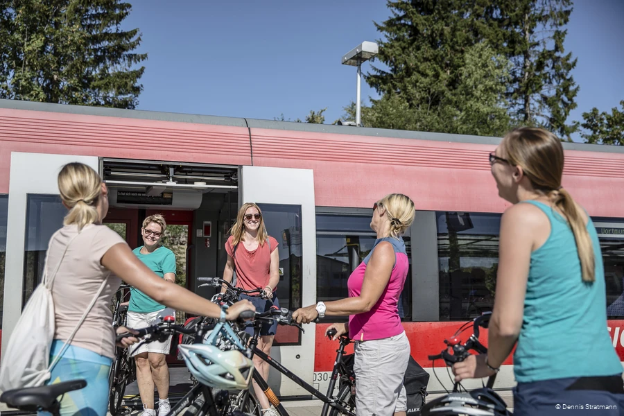 Eine Gruppe junger Frauen steigt mit ihren Fahrr&auml;dern aus dem Zug aus.
