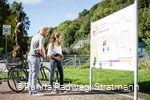 Paar mit Fahrrädern vor einer Stadtinformationstafel auf dem RuhrtalRadweg in Arnsberg
