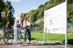 Paar mit Fahrrädern vor einer Stadtinformationstafel auf dem RuhrtalRadweg in Arnsberg
