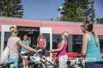 Eine Gruppe junger Frauen steigt mit ihren Fahrrädern aus dem Zug aus.