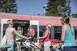 Eine Gruppe junger Frauen steigt mit ihren Fahrrädern aus dem Zug aus.