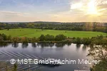 Ein Personenschiff fährt auf der Ruhr und die grünen Ruhrauen im Hintergrund.